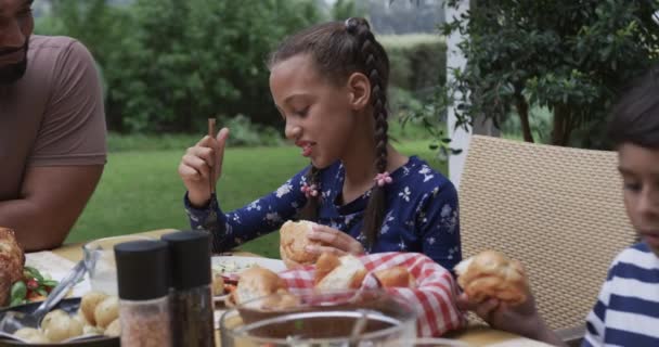 快乐的父亲 儿子和女儿在花园的餐桌边吃饭 动作缓慢 健康生活 生活方式和家庭生活 — 图库视频影像
