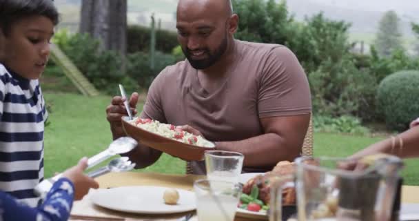 快乐的父母 儿子和女儿在花园的餐桌边吃饭 慢动作 健康生活 生活方式和家庭生活 — 图库视频影像