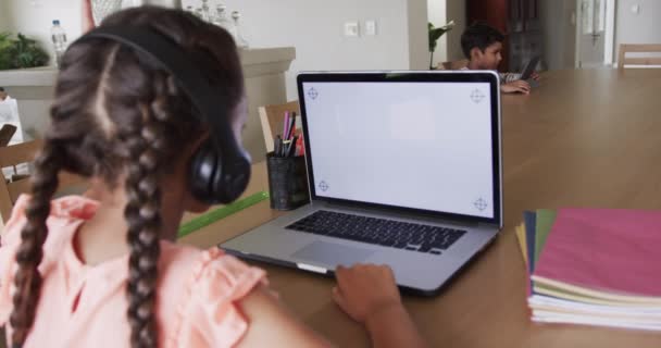 Dwurasowa Dziewczyna Ucząca Się Online Przy Stole Przy Użyciu Laptopa — Wideo stockowe