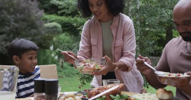 Heureux Parents Biraciaux Fils Fille Dégustant Repas Table Dans Jardin — Video