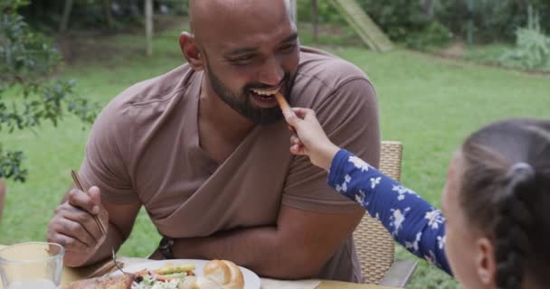 Szczęśliwy Dwurasowy Ojciec Córka Jedzący Posiłek Przy Stole Ogrodzie Zwolnione — Wideo stockowe