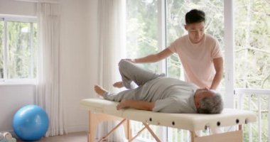 Çeşitli erkek fizyoterapistlerin tavsiyeleri ve ağır çekimde esneme hareketleri. Fizyoterapi, sağlık, refah ve yaşlı yaşam tarzı değişmedi..