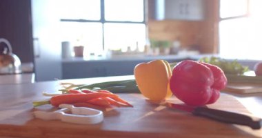 Güneşli mutfakta organik sebzeler ve bıçak, yavaş çekim. Yiyecek, beslenme, dengeli beslenme ve sağlıklı yaşam..