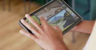Evde güvenlik kamerası görüntüsü olan tablet kullanan melez bir adamın elleri, yavaş çekim. Teknoloji, iletişim, güvenlik ve ev hayatı.