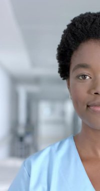 Önlük giymiş, ağır çekimde mutlu bir Afrikalı Amerikalı kadın doktorun dikey portresi. Hastane, ilaç, sağlık ve iş, değiştirilmemiş.