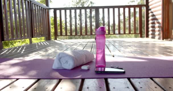 Towel Bottle Water Earphones Smartphone Yoga Mat Log Cabin Slow — Stock Video