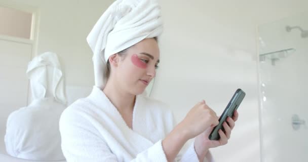 快乐的高加索女人 戴着眼罩 在浴室里用智能手机慢动作 家庭生活 自我照顾和技术 — 图库视频影像