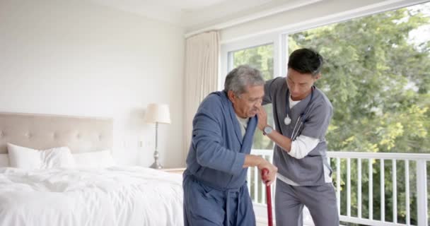 Mångsidig Manlig Läkare Hjälpa Äldre Manliga Patienten Med Promenadkäpp Hemma — Stockvideo