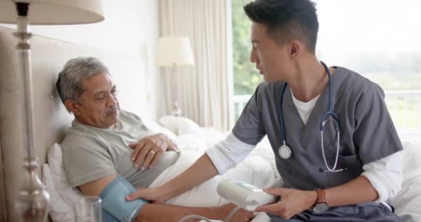 Olika Manliga Läkare Testar Blodtrycket Hos Äldre Manliga Patienten Sängen — Stockvideo