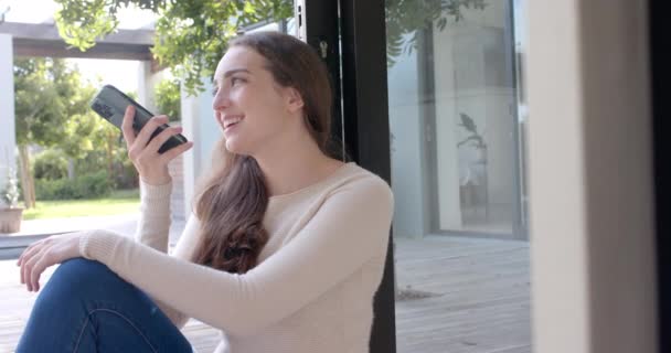 Щаслива Біла Жінка Сидить Підлозі Розмовляє Смартфону Повільному Русі Домашнє — стокове відео