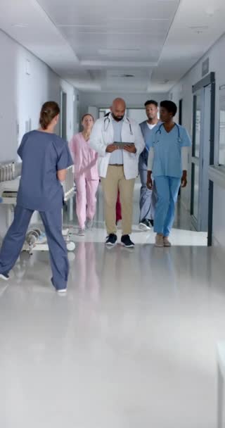 Pionowe Wideo Różnych Lekarzy Korzystających Tabletu Spacerujących Korytarzem Szpitalu Zwolnione — Wideo stockowe