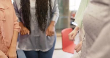 Ofiste ağır çekimde el ele tutuşan çeşitli iş kadınlarının orta kısmı. İş, takım çalışması ve çalışma.