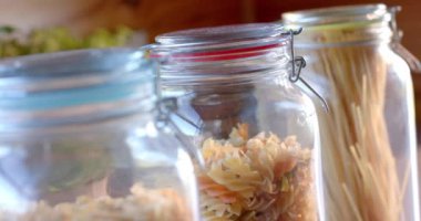 Güneşli mutfakta, tezgahın üstünde yemek kavanozları, yavaş çekim. Yiyecek, beslenme, dengeli beslenme ve sağlıklı yaşam..