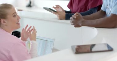 Muhtelif doktorlar hastanede resepsiyonistle konuşuyor, ağır çekimde. Hastane, takım çalışması, iletişim, tıp, sağlık ve iş, değiştirilmemiş.