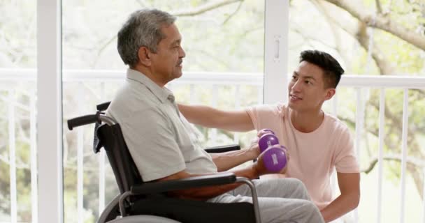 Různorodý Mužský Fyzioterapeut Radí Starší Muž Invalidním Vozíku Používá Činky — Stock video