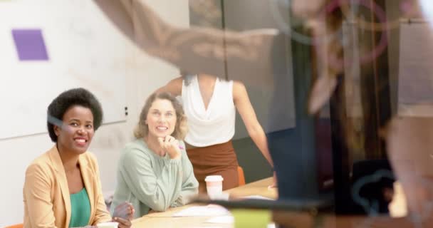 不同的女商人写在玻璃墙上 在办公室里头脑风暴 动作缓慢 团队合作 头脑风暴和工作 — 图库视频影像