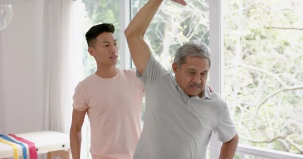 Divers Physiothérapeutes Masculins Conseillant Patient Masculin Âgé Étirant Ralenti Physiothérapie — Video