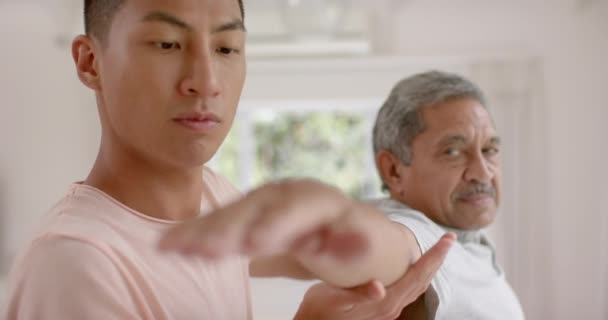 Diverse Männliche Physiotherapeuten Beraten Und Älteren Männlichen Patienten Stretching Zeitlupe — Stockvideo