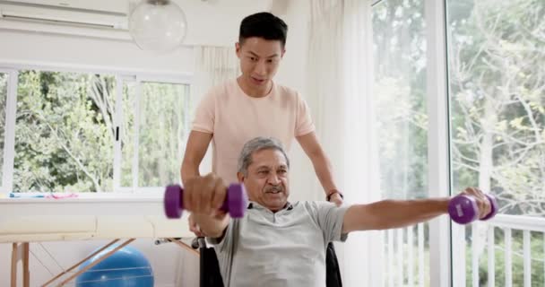 Различные Консультации Физиотерапевта Мужчины Пожилого Человека Инвалидном Кресле Используя Гантели — стоковое видео