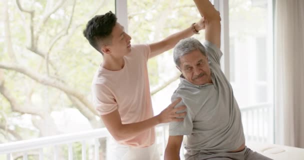 Olika Manliga Sjukgymnast Rådgivare Och Senior Manliga Patienten Stretching Slow — Stockvideo