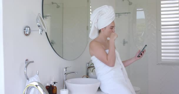 Λευκή Γυναίκα Βουρτσίζει Δόντια Και Χρησιμοποιεί Smartphone Πετσέτα Στο Κεφάλι — Αρχείο Βίντεο