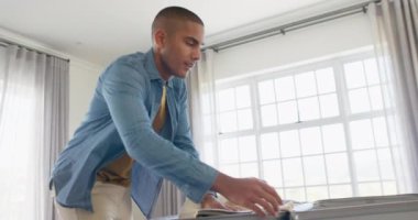 Parlak yatak odasında bavul hazırlayan mutlu çift ırklı adam. Seyahat, tatil, boş zaman ve yaşam tarzı, değiştirilmemiş..