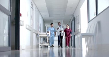 Çeşitli doktorlar işi tartışıyor ve koridorda ağır çekimde yürüyorlar. Hastane, takım çalışması, iletişim, tıp, sağlık ve iş, değiştirilmemiş.