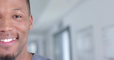 Koridorda gülümseyen mutlu çift ırklı erkek doktorun portresi, kopyalama alanı, yavaş çekim. Hastane, ilaç, sağlık ve iş, değiştirilmemiş.