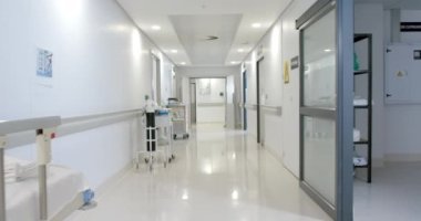Hastanedeki sedyeli ve tekerlekli sandalyeli genel koridor manzarası, yavaş çekim. Hastane, ilaç, sağlık ve iş.