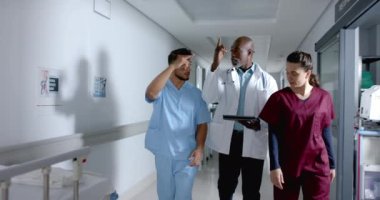 Çeşitli doktorlar işi tartışıyor ve koridorda ağır çekimde yürüyorlar. Hastane, takım çalışması, iletişim, tıp, sağlık ve iş, değiştirilmemiş.