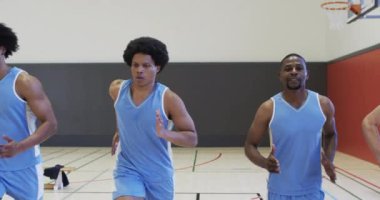 Çeşitli erkek basketbol takımları antrenmanlarına odaklanmış, kapalı sahada koşuyor, ağır çekimde. Spor, antrenman, spor ve takım aktiviteleri, değiştirilmemiş..