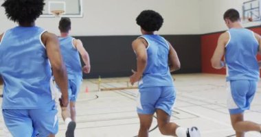 Çeşitli erkek basketbol takımları antrenman yapıyor, iç sahada koşuyor ve dönüyor, yavaş çekim. Spor, antrenman, spor ve takım aktiviteleri, değiştirilmemiş..