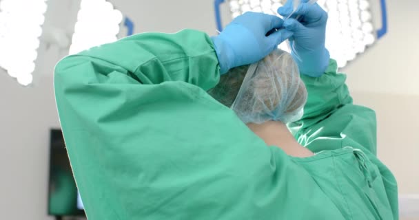 手術用ガウンとキャップを身に着けている白人女性外科医 ゆっくりとした動き 医療および仕事 変わらない — ストック動画
