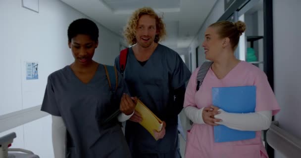 快乐多样的医生在医院走廊里聊天和散步 动作缓慢 团队合作 保健和工作 — 图库视频影像