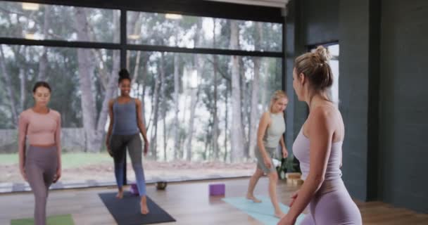 集中在瑜伽课上与女教练一起伸展在垫子上的多样化女性 动作缓慢 运动和健康的生活方式 — 图库视频影像