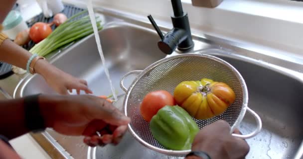台所で野菜をすすいでいるアフリカ系アメリカ人のカップルの手 スローモーション 食べ物 健康的な生活 団結と国内生活 変わらない — ストック動画