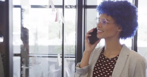 Portrait Biracial Businesswoman Making Notes Glass Wall Talking Smartphone Slow — Stock Video