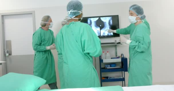 수술용 가운을 착용한 다양한 외과의사들이 수술용 슬로우 모션에서 엑스레이 스캔을 — 비디오