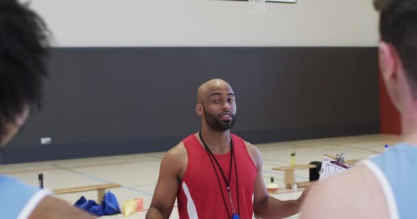 Různorodý Mužský Basketbalový Trenér Zápisníkem Instruktážní Tým Vnitřním Hřišti Zpomaleném — Stock video