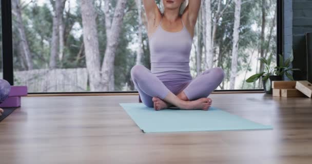ヨガクラスのマットで一緒に瞑想する多様な女性に焦点を当て スローモーション フィットネス 運動と健康的なライフスタイル 変更なし — ストック動画