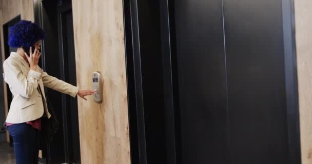 一个有着蓝色黑人血统的女商人用智能手机说话 用电梯 慢动作 临时办公室 通信和工作 — 图库视频影像