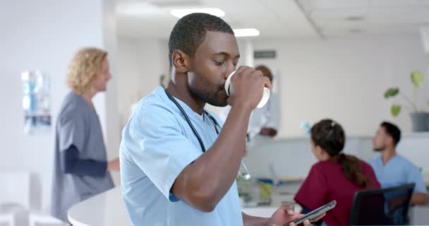 Portrait African American Male Doctor Drinking Coffee Using Smartphone Corridor — Stock Video