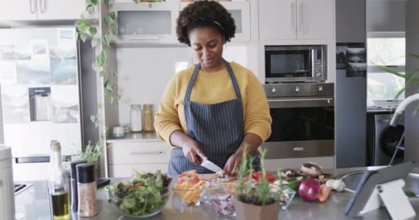 Lykkelig Afroamerikansk Kvinne Forkle Som Hogger Grønnsaker Kjøkkenet Sakte Film – stockvideo