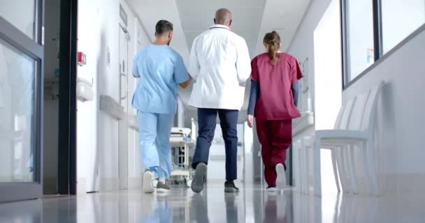 Zróżnicowani Lekarze Omawiający Pracę Chodzenie Korytarzem Szpitalu Zwolnione Tempo Szpital — Wideo stockowe