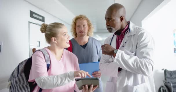 Olika Läkare Diskuterar Arbete Och Använda Tablett Korridoren Sjukhus Slow — Stockvideo