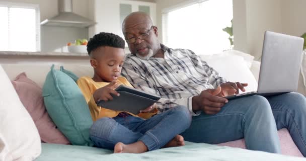 Африканский Американский Дедушка Внуком Использующий Планшет Ноутбук Диване Дома Замедленная — стоковое видео