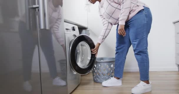 Afroamerikansk Kvinna Som Lägger Kläder Tvättmaskinen Tvättar Hemma Rör Sig — Stockvideo