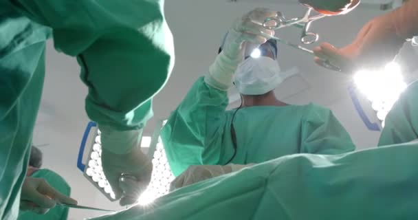 수술용 가운을 착용하고 다양한 외과의사들이 수술용 슬로우 모션으로 환자를 수술하고 — 비디오