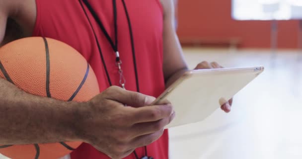 中段的比利奇男子篮球教练带球在室内场地使用平板 动作缓慢 交流和团队活动 — 图库视频影像