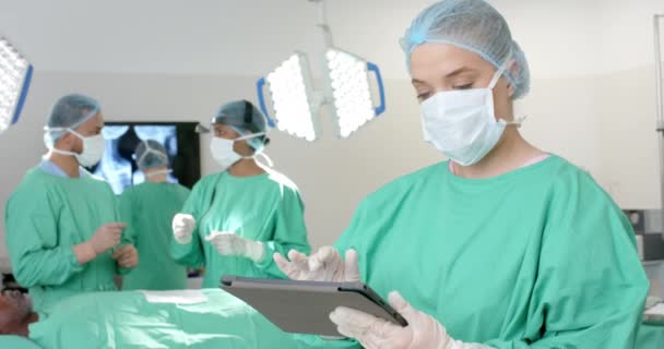 Portretul Chirurgului Masculin Caucazian Purtând Rochie Chirurgicală Folosind Tableta Mișcarea — Videoclip de stoc